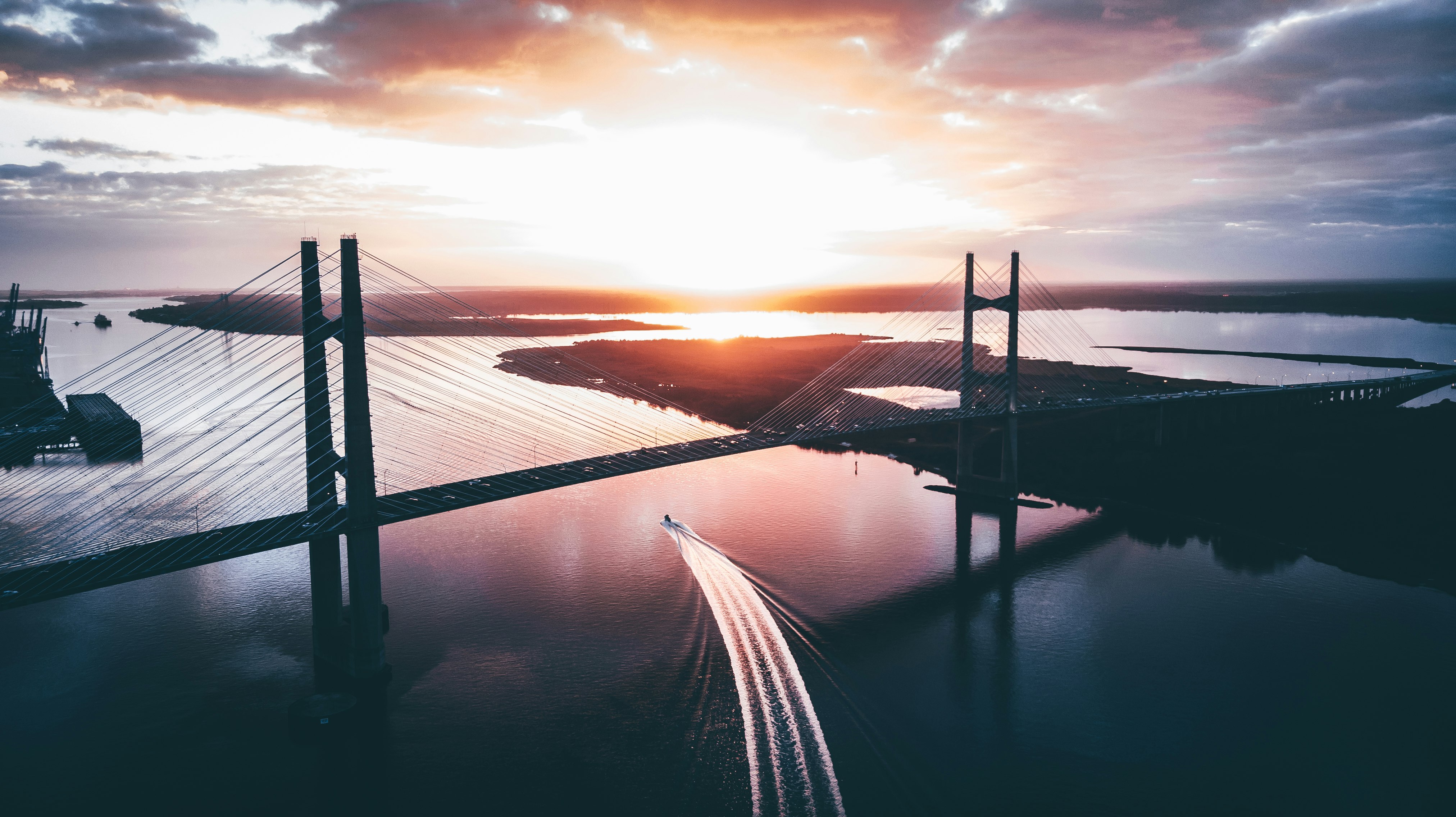 silhouette of ship traveling during sunset